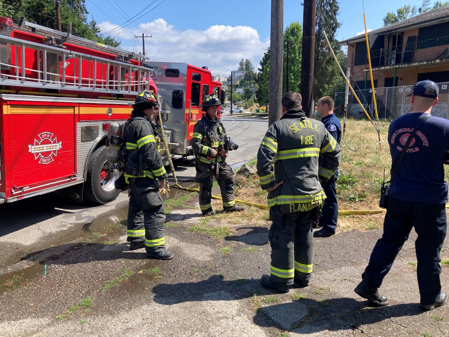 Seattle firefighters  stand near a fire engine.