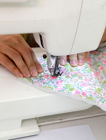 Hands working a sewing machine