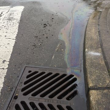 A storm drain in a street.
