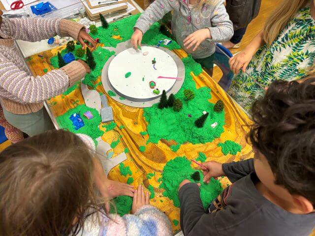 Tabletop model made with clay, paper, and miniature trees.