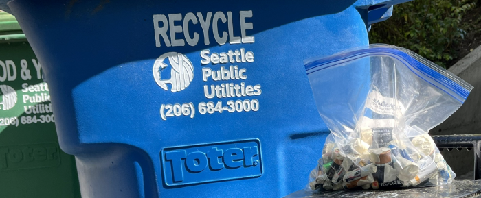A bag of batteries and a recycling bin.