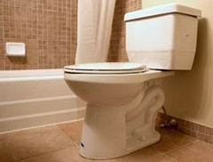 Typical residential bathroom with toilet and tub in background.