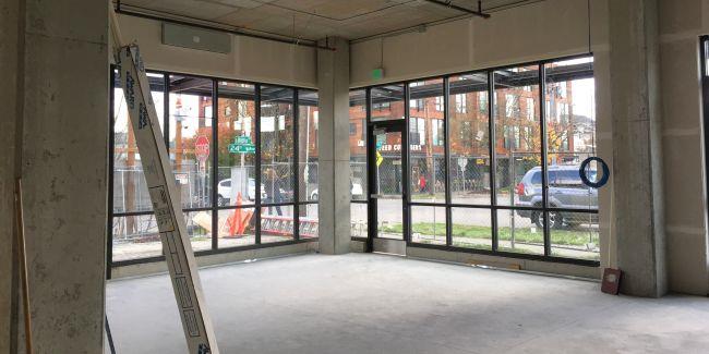 Un cuarto vac&iacute;o en un edificio nuevo, con pisos de concreto y ventanas 