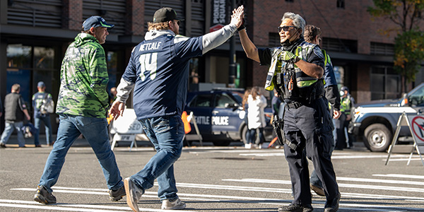 Officer giving high five to pedestrian from seahawks game