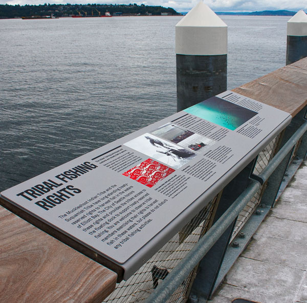 A placard along a pier rail that tells the story of tribal fishing rights