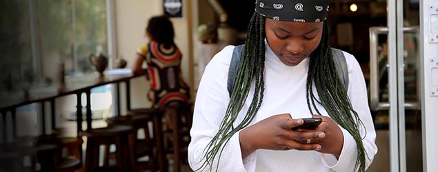 A person checks their phone outside a cafe