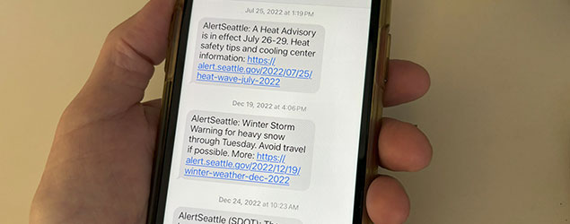 A cell phone is shown with AlertSeattle text alerts