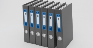 six binders, each with a single letter on its binding which all together spells "budget"
