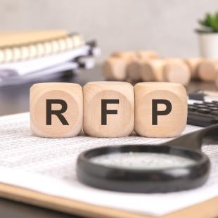 wooden blocks with the letters "RFP" and a magnifying glass