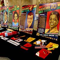 Four display posters titled "African Americans of STEM" displayed on a table along with artifacts invented by African Americans.