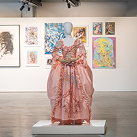 A pink dress with various acrylic illustrations on it.