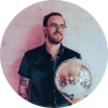 Zach Frimmel wears glasses and holds disco ball.