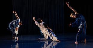Three Black dancers in various poses, each with one arm extended. One is bent at the waist, one kneels, one bends to the side.