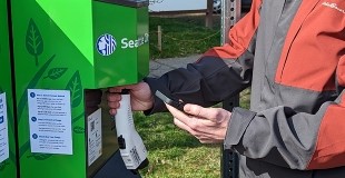 Person scanning QR code on a curbside Level 2 electric vehicle charger.