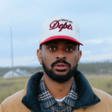 Abdul wearing a hat standing outside