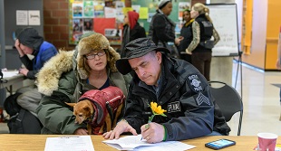 A person and their pet receives help in a severe weather shelter