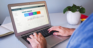 A person views statistics on a laptop screen