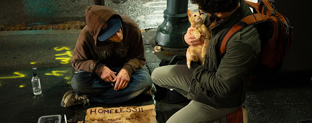 A man with a kitchen talks with a homeless man on a street