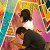 photo of two people painting a colorful mural