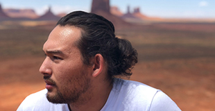 Eric Alipio in profile with a desert scene behind him.