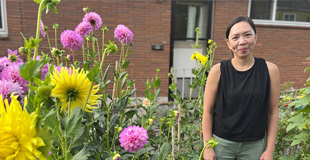 P-Patch Gardener smiling with dahlias in the background