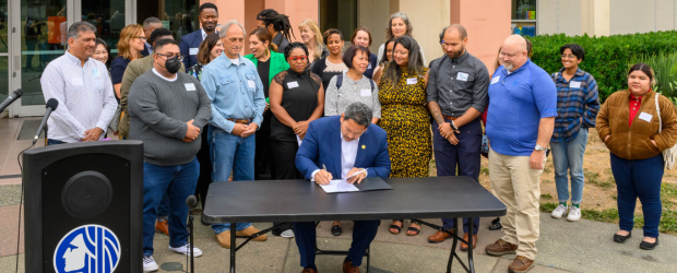 Mayor Harrell, CM Mosqueda, and Green New Deal Oversight Board Members together as Mayor signs legislation at table. 
