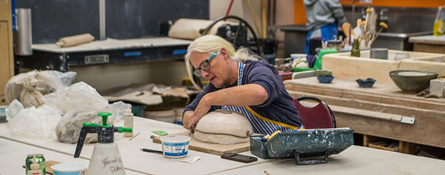 Older woman working on a ceramic bowl in an art studio