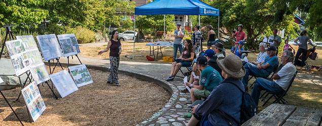 A group of people sitting outside watching a Parks presentation