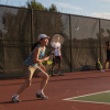 A person playing tennis on an outdoor court