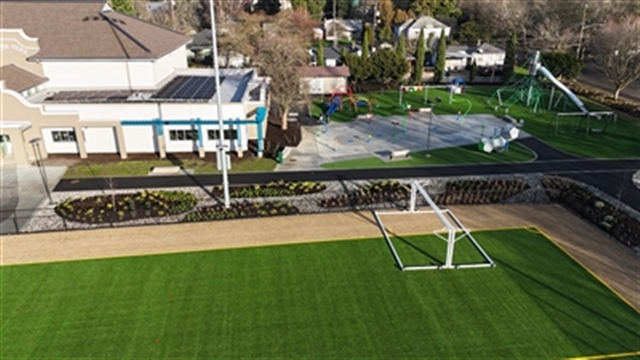 Aerial view of South Park Playground wit turf field, landscaped walkways, and a large colorful playground 