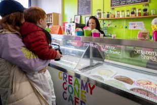 A woman serving customers at Creamy Cone Cafe, an ice cream shop in Rainier Beach