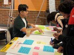 A city staff member showing a group of kids how to do a feedback activity