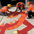 Crew installing a dragon decal, designed by Lawrence Augustine