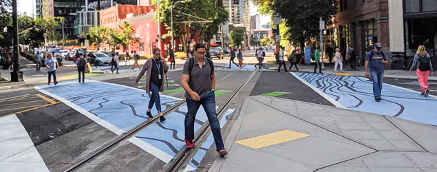 Pedestrians walk on a decorative crosswalk in Westlake in downtown Seattle