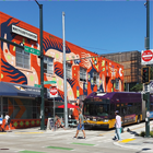 Intersection in the UDistrict featuring a transit street and building with a new mural 
