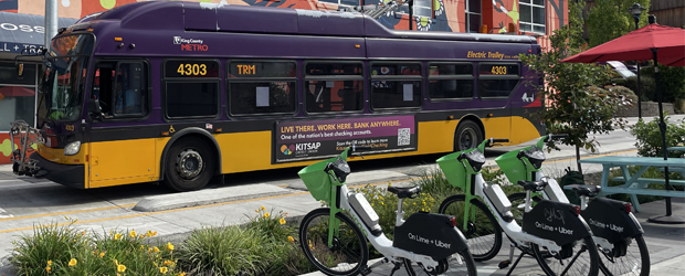 A Metro Bus parked against a mural with eBikes lined up on the sidewalk