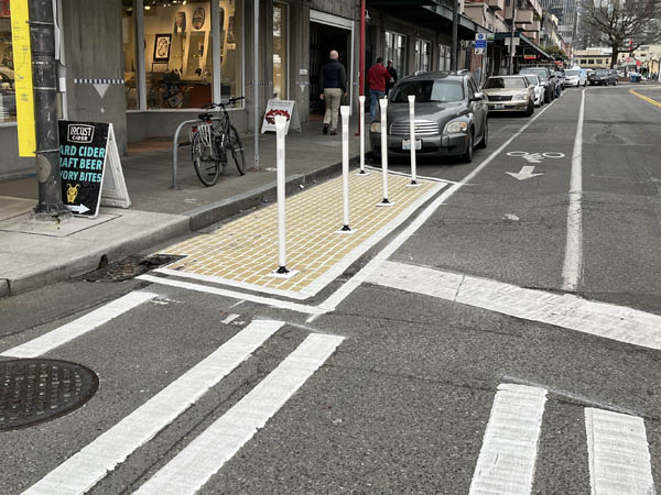 Example of markings on the street and flexible posts that help improve visibility at an intersection  