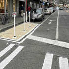 Example of markings on the street and flexible posts that help improve visibility at an intersection  