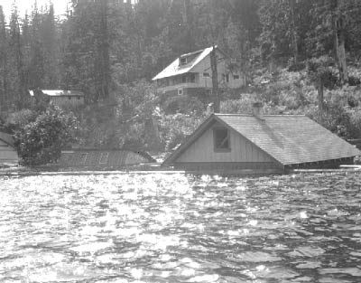 A house is submerged in floodwaters up to its roof line.