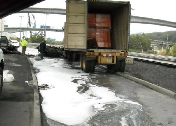 Photo of an accident scene with a semi truck trailer and spill response measures.