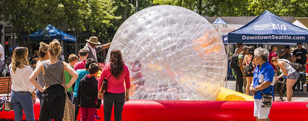 A crowd waits in line to play in a large inflatable ball