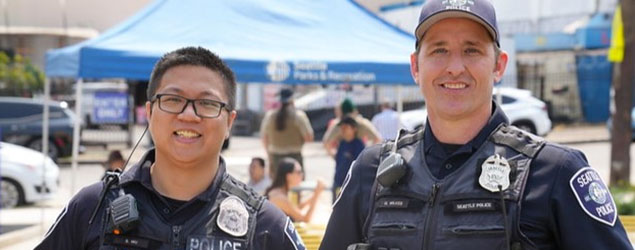 Two police officers smile for the camera at an outdoor event