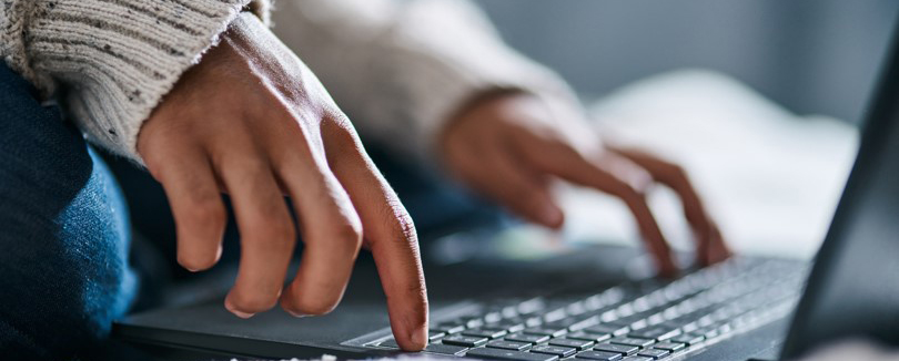 Hands typing on a laptop computer. 