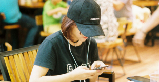 Woman sitting in a bookstore looking at her phone