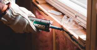 Person adding insulation to a window sill and wall