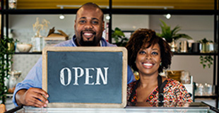Business owners standing next to a pasty case