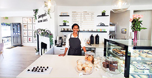 A business owner standing next to a pasty case