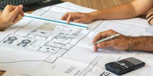 People working on a large printed architectural floor plan