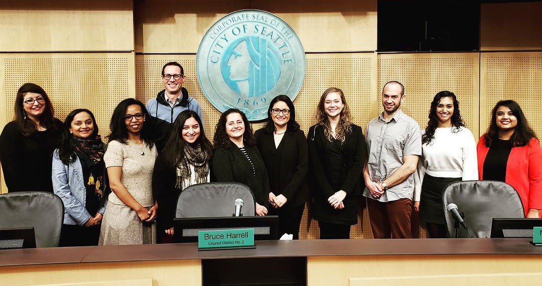 Group picture of some of the Immigrant and Refugee Commissioners in Council Chambers.