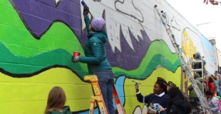 Community members painting a mural